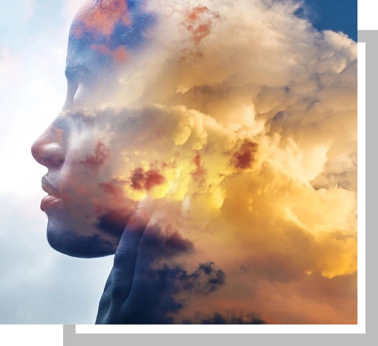 A double exposure of a person 's face and clouds.