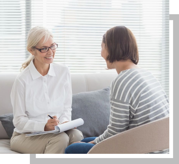 A woman sitting on the couch talking to another person.